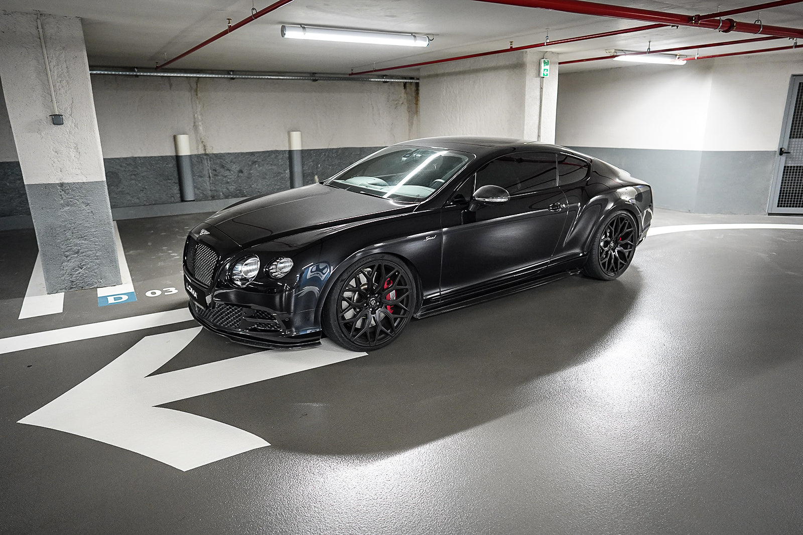Profile view of black Bentley Continental GT with 22-inch custom rims